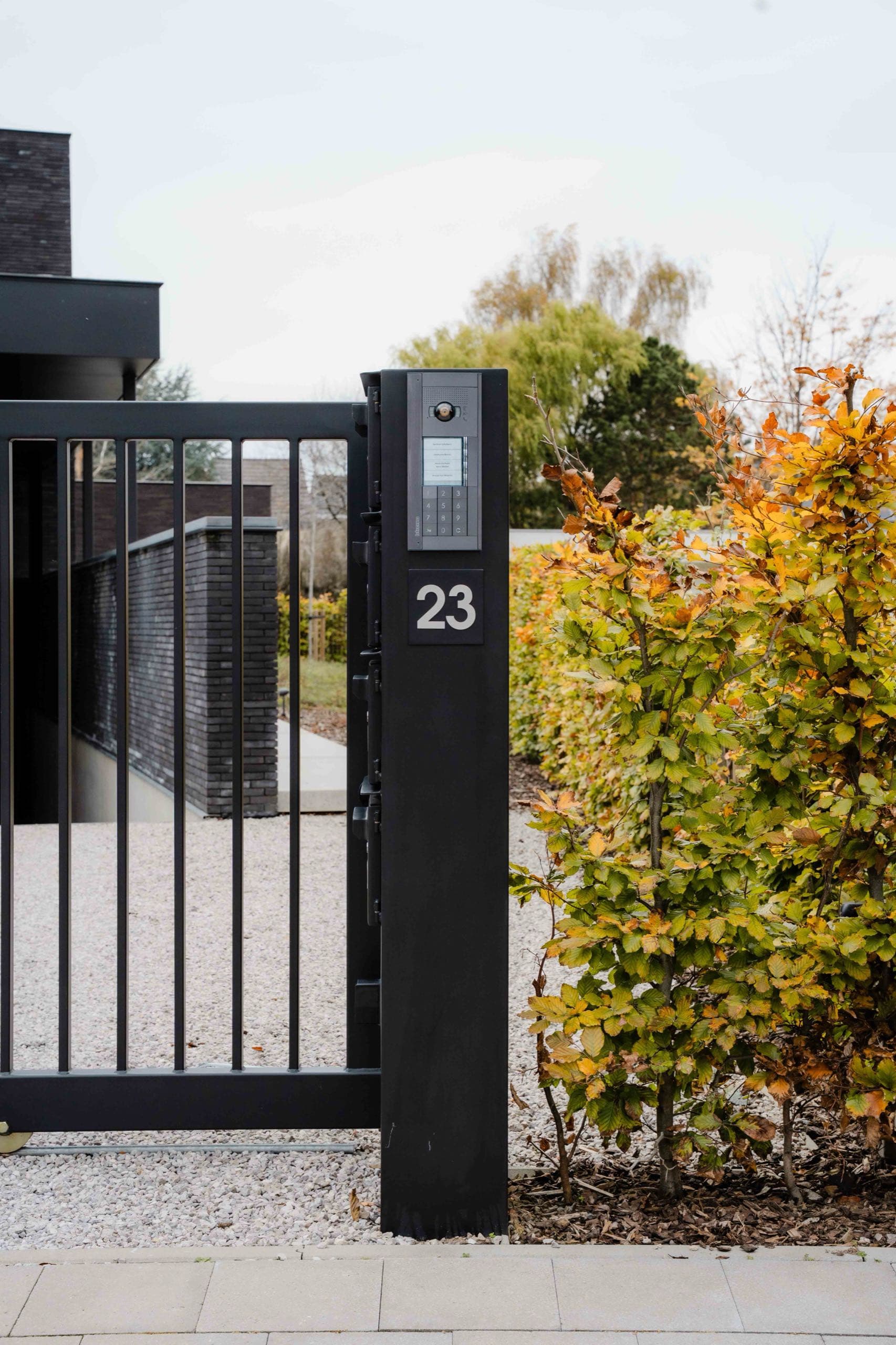 Matzwarte stalen poort en intercom-zuil met huisnummer 23 aan woning in Aalst